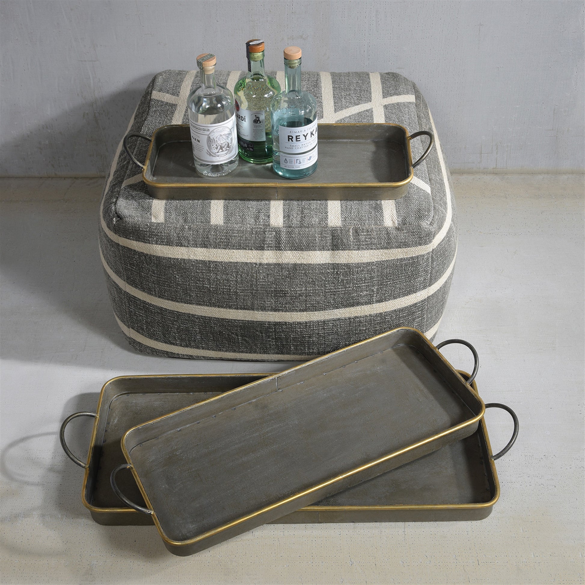 Three long galvanized grey trays with thin brass rims, nested