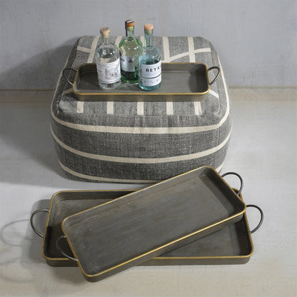 Three long galvanized grey trays with thin brass rims, nested