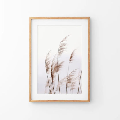 Beige dried grass print in a thin oak frame with mat, hung above a neutral console