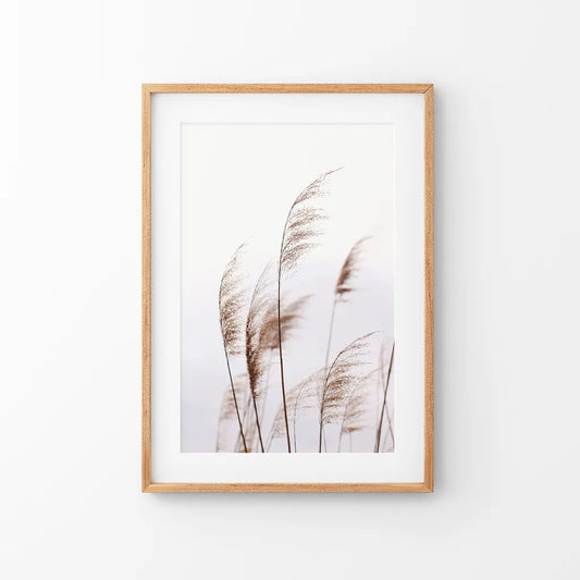 Beige dried grass print in a thin oak frame with mat, hung above a neutral console