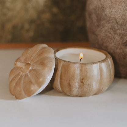 Lit pumpkin spice soy candle in a brushed tan ceramic pumpkin jar with lid alongside