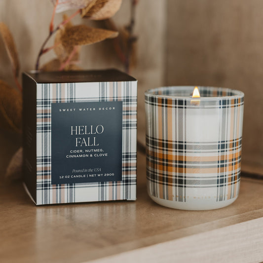 Lit Hello Fall soy candle in autumn plaid glass beside its matching plaid box