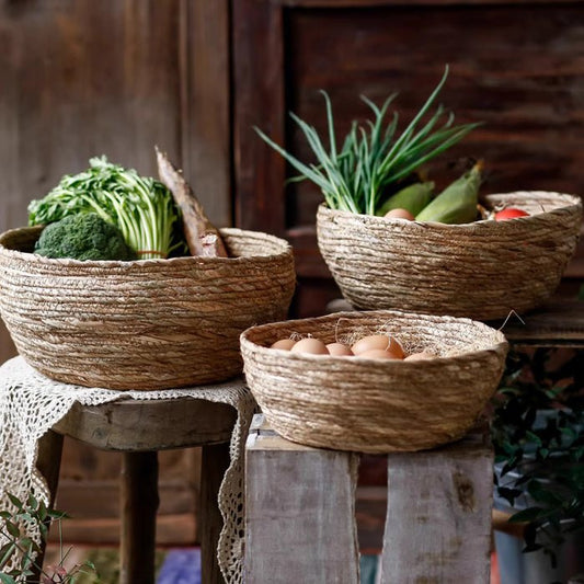 Seagrass bowl baskets holding fresh vegetables and eggs on rustic stools