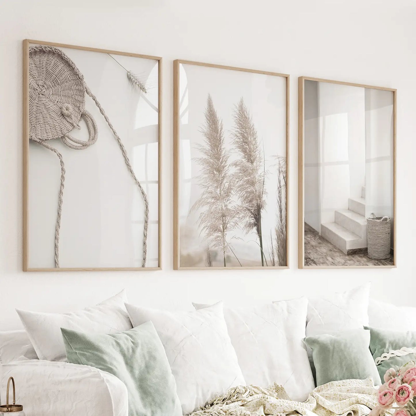 Set of three pampas grass and woven-texture prints in wood frames above a sofa