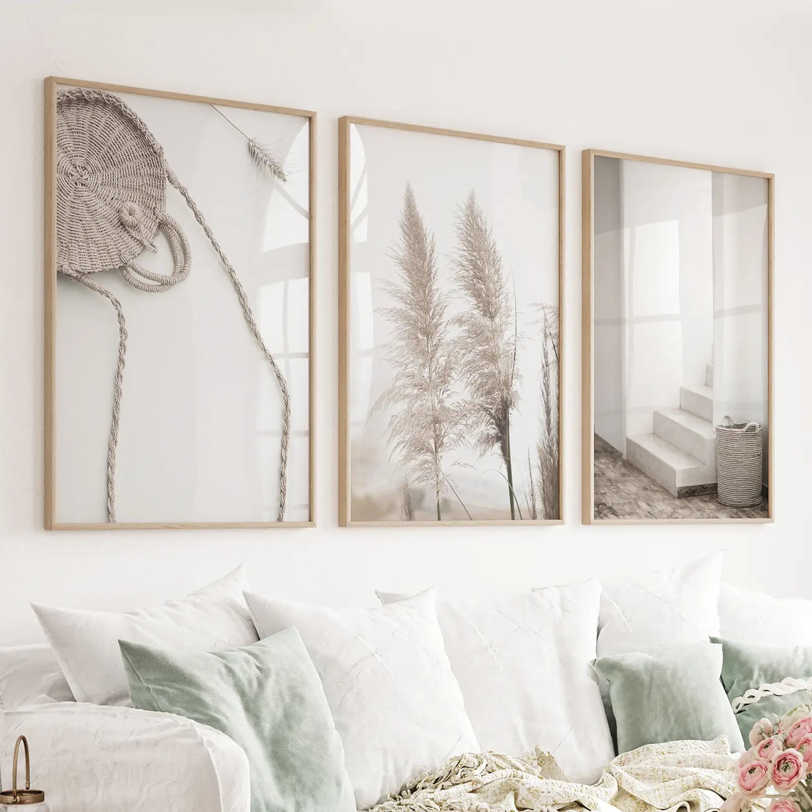 Set of three pampas grass and woven-texture prints in wood frames above a sofa