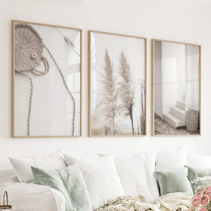 Set of three pampas grass and woven-texture prints in wood frames above a sofa