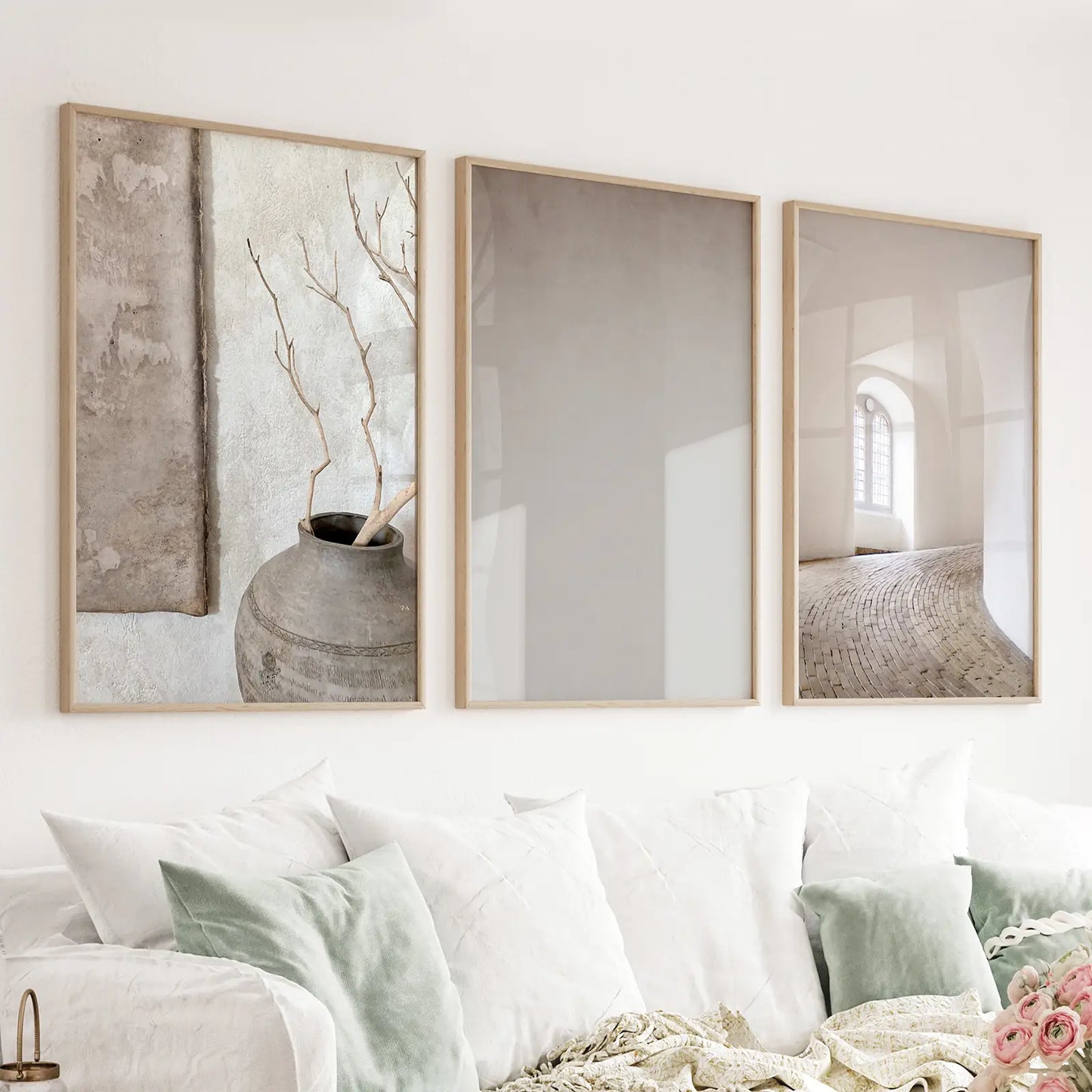 Set of three beige architectural prints in wood frames above a neutral sofa