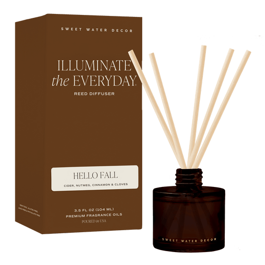 Hello Fall reed diffuser with pale reeds in an amber glass jar beside its brown box