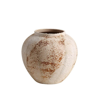 Round weathered pottery jar in mottled limewash, front view