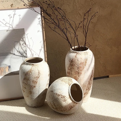 Weathered pottery vases in chalky limewash — round jar and tall jar styled with dried branches