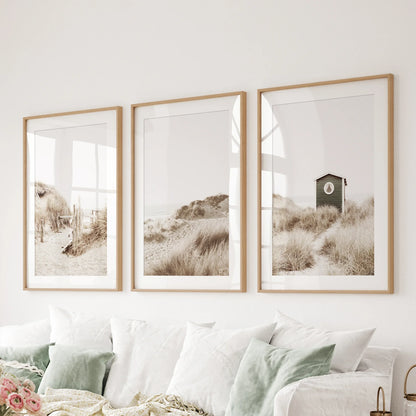 Coastal three-piece print set in thin oak frames with mats above a family room sofa