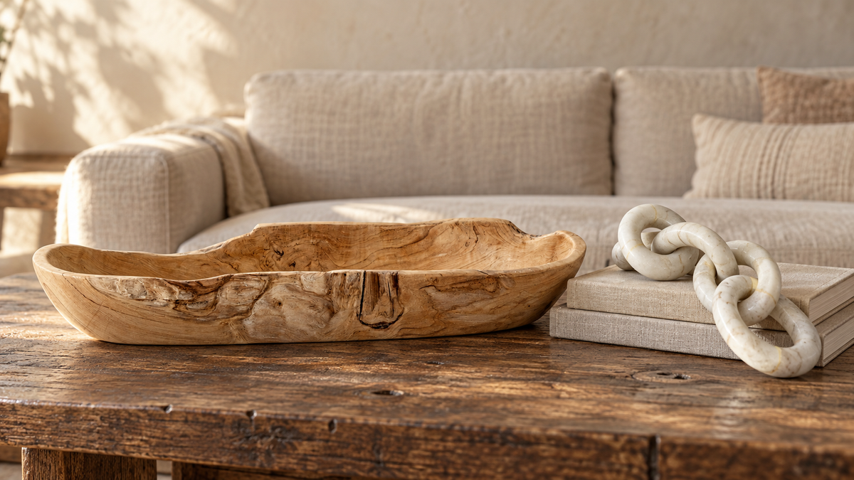 Natural teak bowl and ivory marble chain on a warm wood coffee table